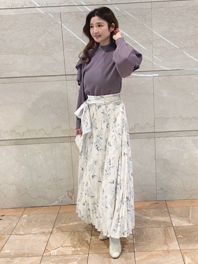 ホワイト系のスカート、パープル系のニット/セーターを着用したレディースの冬コーディネートの2枚目の写真