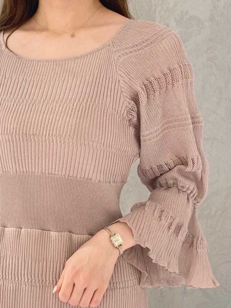 ベージュ系のワンピース、ホワイト系のハンドバッグ、ホワイト系のパンプスを着用したレディースの冬コーディネートの5枚目の写真