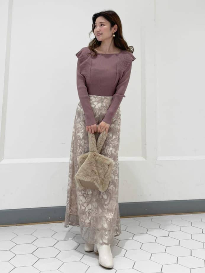 ブラウン系のニット/セーター、ベージュ系のハンドバッグ、ピンク系のスカートを着用したレディースの秋コーディネートの2枚目の写真