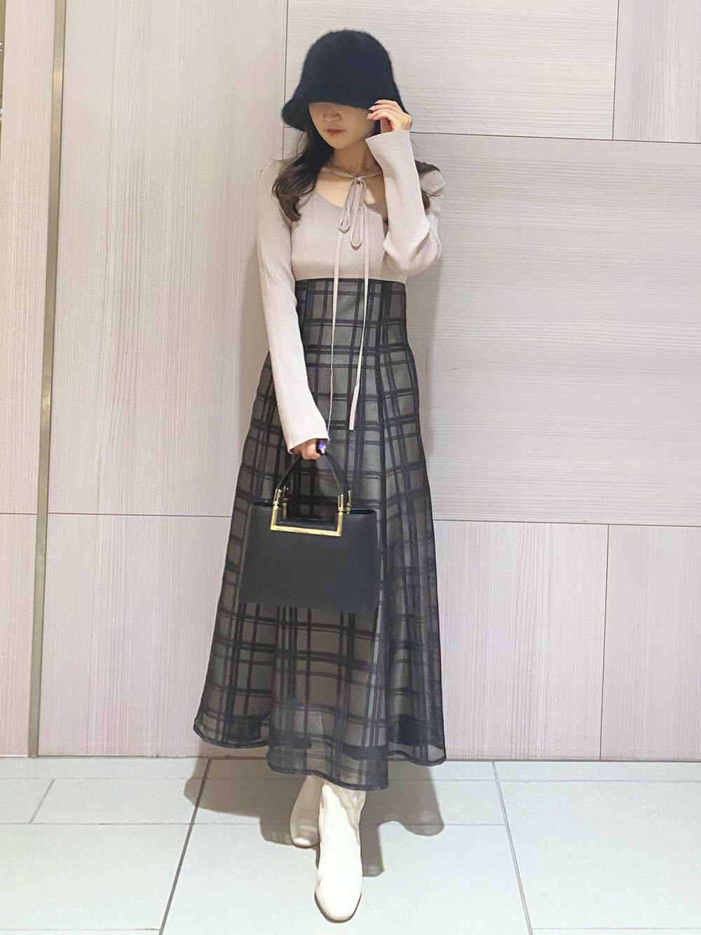 ピンク系のワンピース、ブラック系のハンドバッグ、ホワイト系のブーツを着用したレディースの秋コーディネートの2枚目の写真