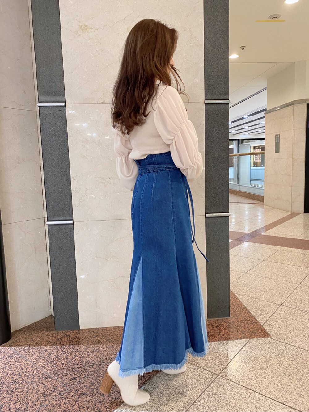 ブルー系のスカート、ベージュ系のニット/セーターを着用したレディースの冬コーディネートの3枚目の写真