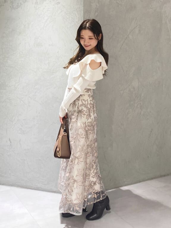 ブラウン系のハンドバッグ、ホワイト系のニット/セーター、ピンク系のスカートを着用したレディースの秋コーディネートの5枚目の写真