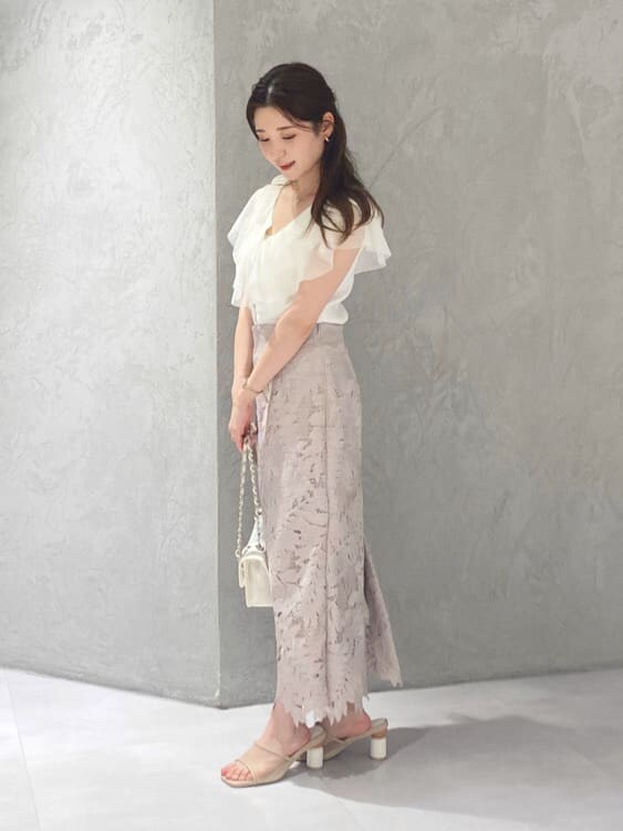 ピンク系のスカート、ベージュ系のサンダル、ホワイト系のカーディガン/ボレロを着用したレディースの夏コーディネートの4枚目の写真