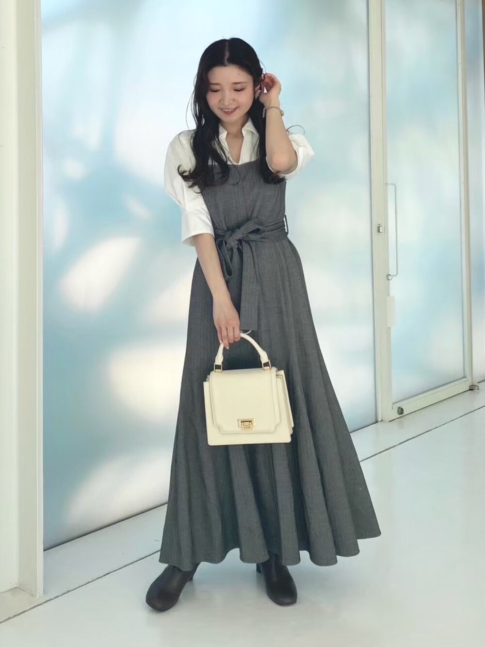 ホワイト系のハンドバッグ、その他のワンピース、ブラウン系のブーツを着用したレディースの秋コーディネートの2枚目の写真