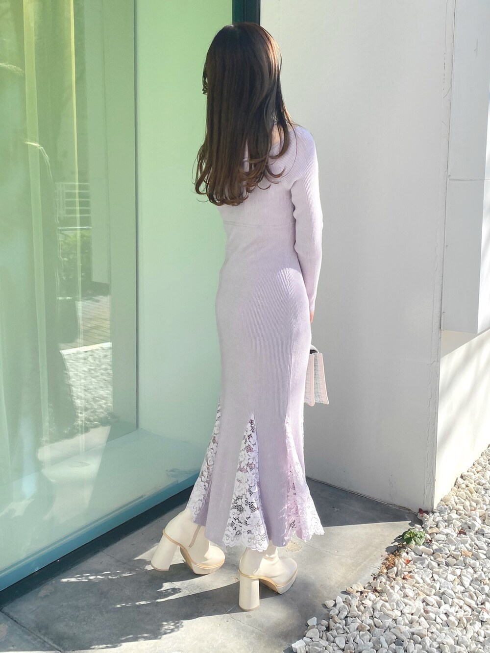 ホワイト系のショルダーバッグ、ピンク系のワンピース、ホワイト系のブーツを着用したレディースの冬コーディネートの6枚目の写真