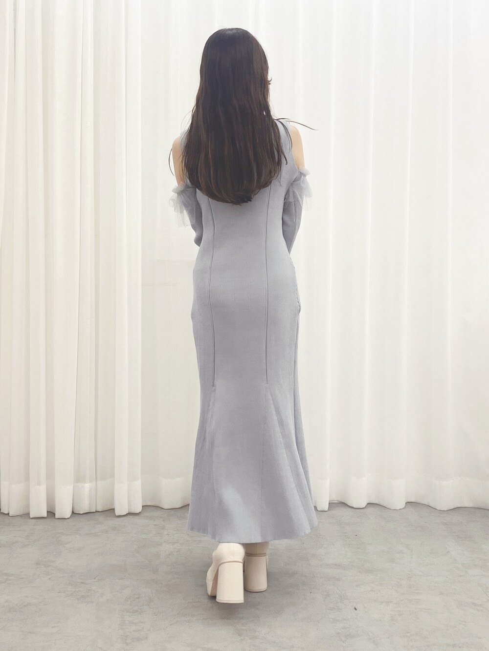 ホワイト系のブーツ、ブルー系のワンピース、ホワイト系のハンドバッグを着用したレディースの秋コーディネートの7枚目の写真