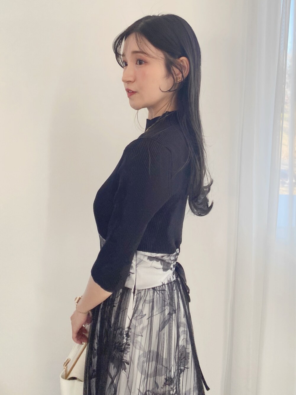 ブラック系のサンダル、ホワイト系のハンドバッグ、ブラック系のワンピースを着用したレディースの春コーディネートの3枚目の写真