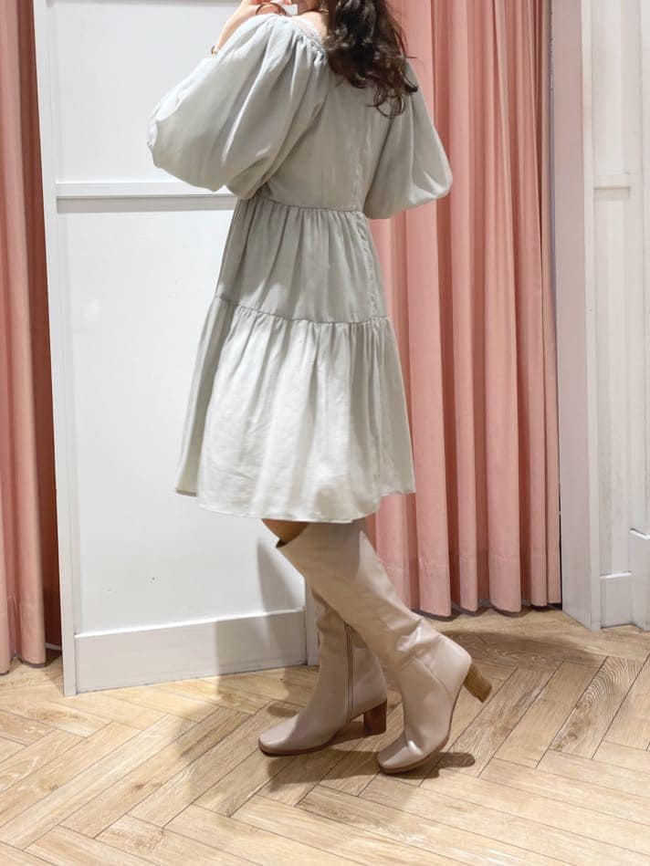 グリーン系のワンピース、ベージュ系のブーツ、ベージュ系のキャスケットを着用したレディースの秋コーディネートの7枚目の写真