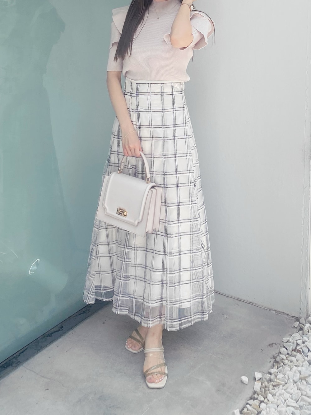 ホワイト系のサンダル、ホワイト系のハンドバッグ、ホワイト系のスカートを着用したレディースの夏コーディネートの2枚目の写真