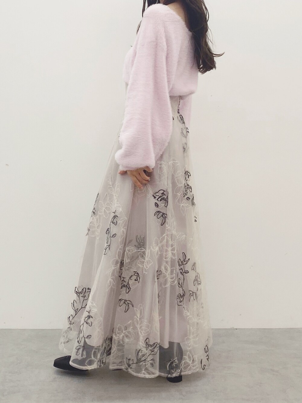 ピンク系のハンドバッグ、ブラック系のブーツ、ピンク系のニット/セーターを着用したレディースの秋コーディネートの2枚目の写真