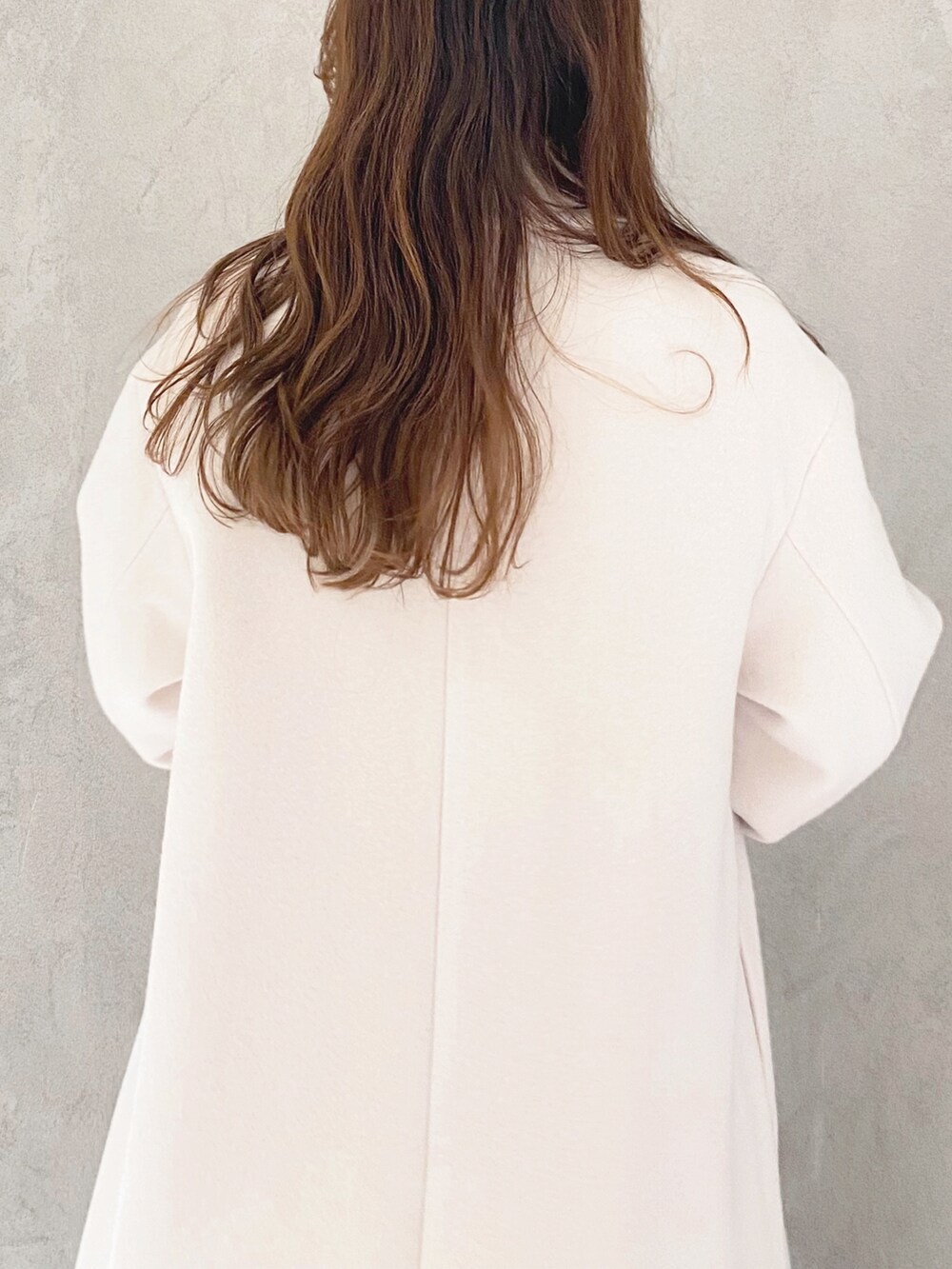 ホワイト系のチェスターコート、ホワイト系のブーツ、パープル系のニット/セーターを着用したレディースの冬コーディネートの6枚目の写真