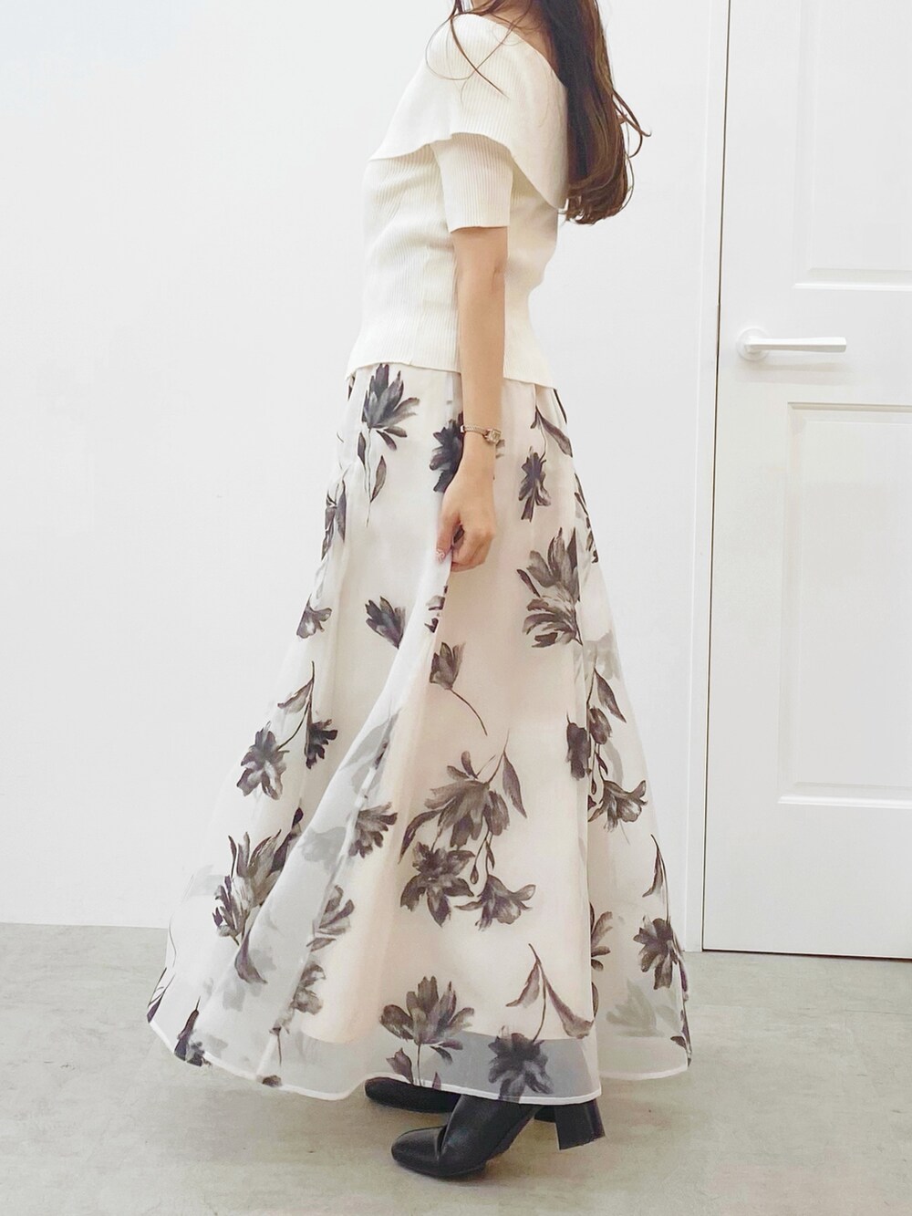 ホワイト系のニット/セーター、ホワイト系のスカート、ホワイト系のハンドバッグを着用したレディースの秋コーディネートの2枚目の写真