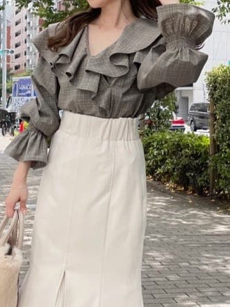 ホワイト系のスカート、ホワイト系のハンドバッグ、ホワイト系のブーツを着用したレディースの秋コーディネートの4枚目の写真