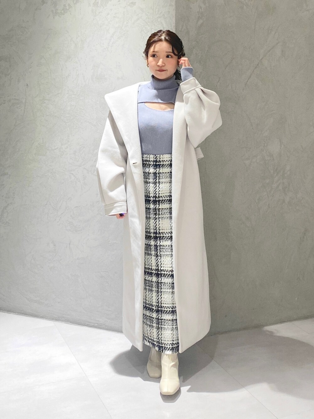 ホワイト系のスカート、ブルー系のニット/セーター、ホワイト系のチェスターコートを着用したレディースの冬コーディネートの9枚目の写真