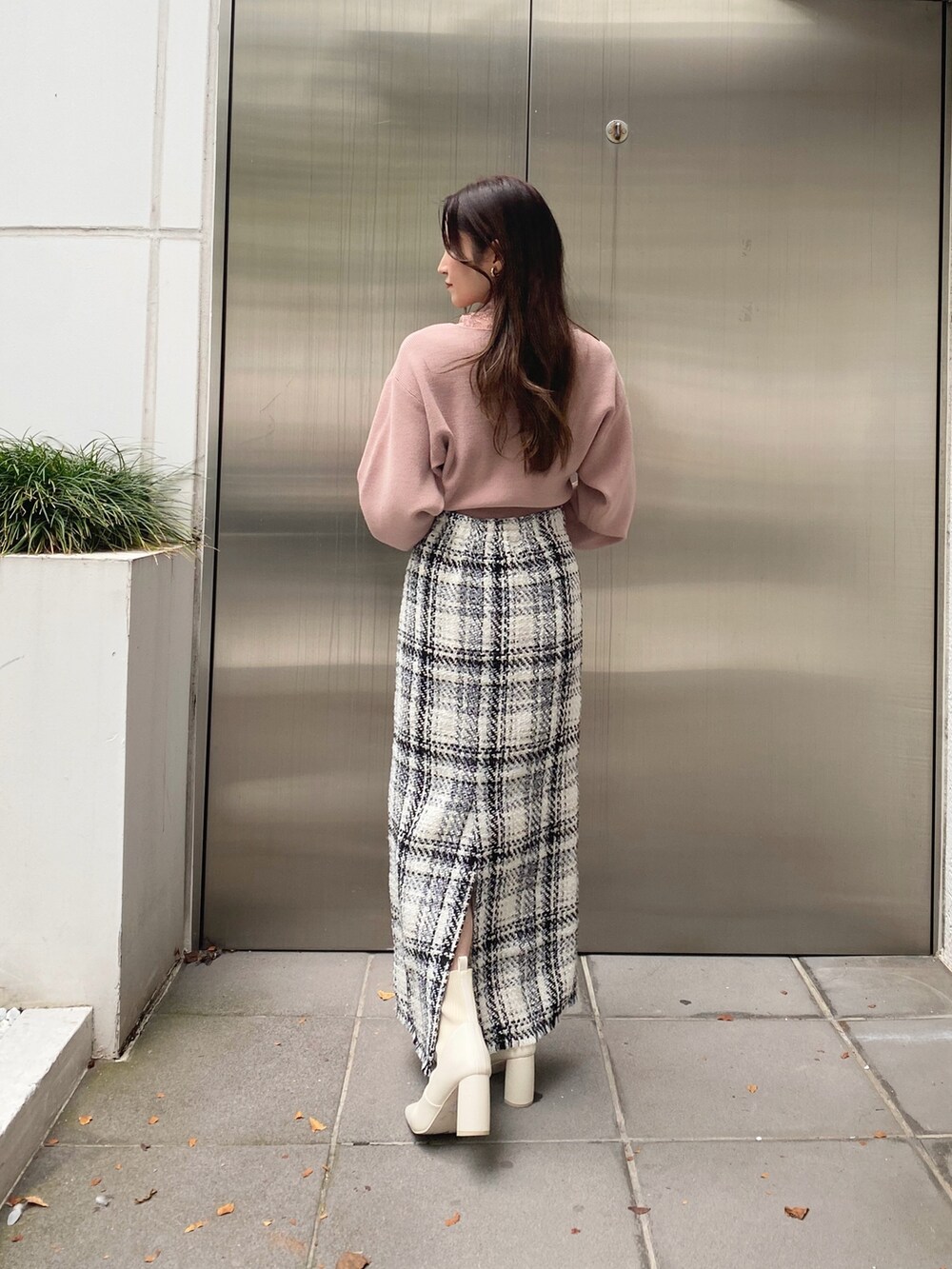 ホワイト系のスカート、ピンク系のニット/セーター、ホワイト系のブーツを着用したレディースの秋コーディネートの5枚目の写真