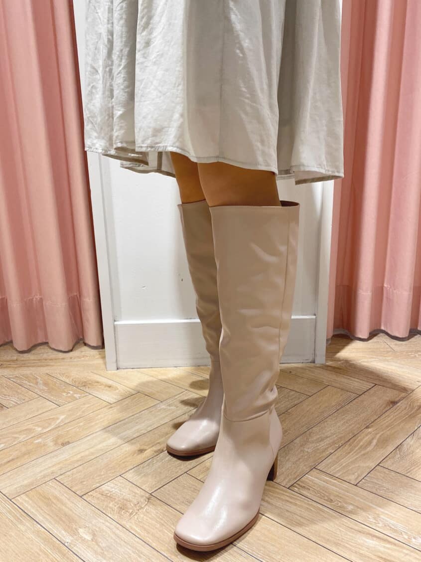 グリーン系のワンピース、ベージュ系のブーツ、ベージュ系のキャスケットを着用したレディースの秋コーディネートの8枚目の写真