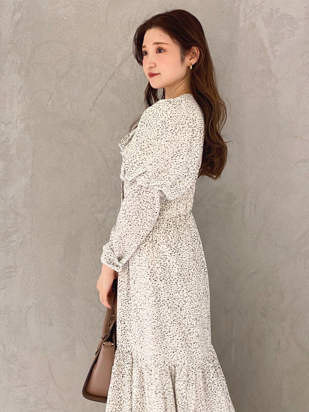 ホワイト系のワンピース、ホワイト系のブーツ、ブラウン系のハンドバッグを着用したレディースの冬コーディネートの5枚目の写真