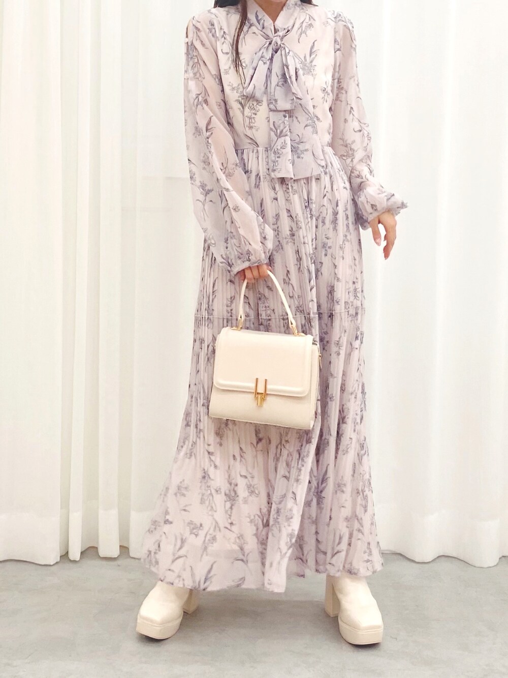 ホワイト系のハンドバッグ、ホワイト系のブーツ、ピンク系のワンピースを着用したレディースの秋コーディネートの3枚目の写真