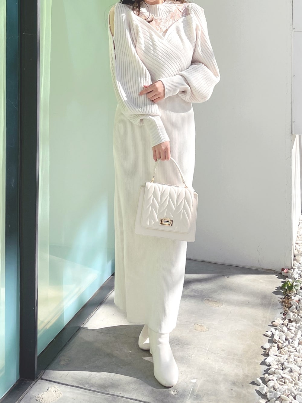 ホワイト系のブーツ、ホワイト系のショルダーバッグ、ホワイト系のワンピースを着用したレディースの冬コーディネートの2枚目の写真