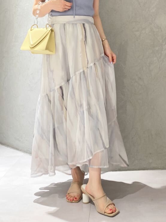 ピンク系のスカート、ブルー系のニット/セーター、ベージュ系のサンダルを着用したレディースの春コーディネートの6枚目の写真