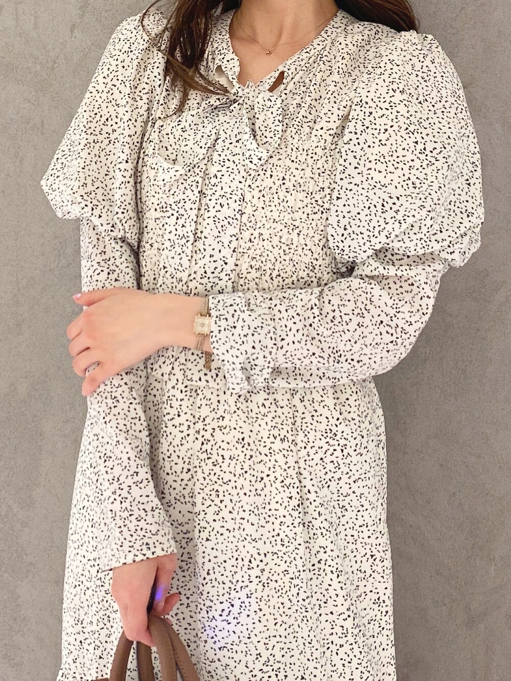 ホワイト系のワンピース、ホワイト系のブーツ、ブラウン系のハンドバッグを着用したレディースの冬コーディネートの7枚目の写真