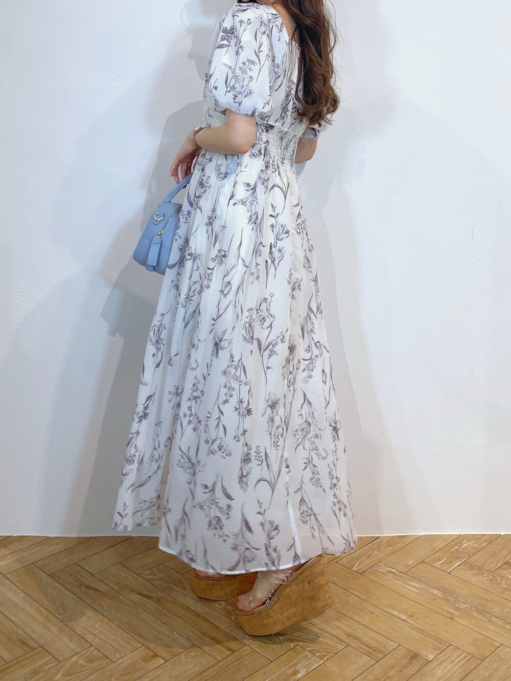 ブルー系のボストンバッグ、その他のサンダル、ホワイト系のワンピースを着用したレディースの夏コーディネートの3枚目の写真