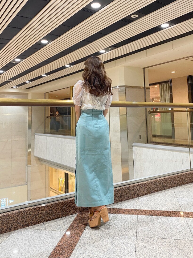 ベージュ系のトートバッグ、グリーン系のスカート、グリーン系のサンダルを着用したレディースの春コーディネートの3枚目の写真