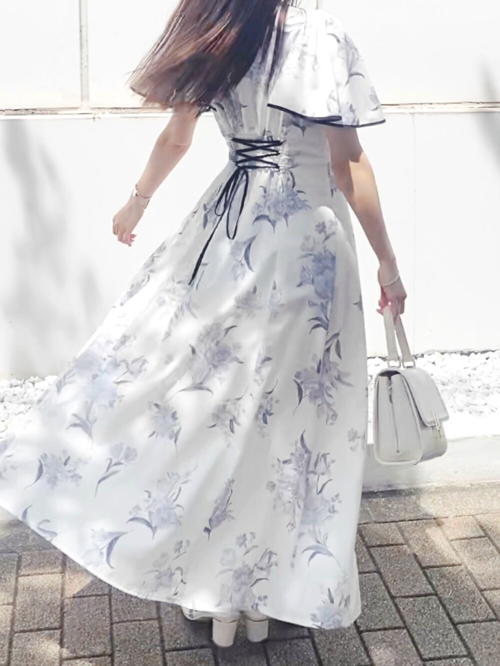 ホワイト系のサンダル、ホワイト系のワンピース、ホワイト系のハンドバッグを着用したレディースの夏コーディネートの2枚目の写真