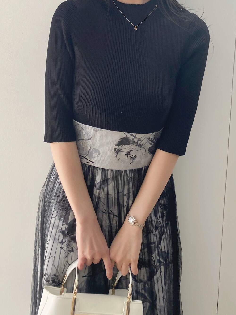 ブラック系のサンダル、ホワイト系のハンドバッグ、ブラック系のワンピースを着用したレディースの春コーディネートの4枚目の写真