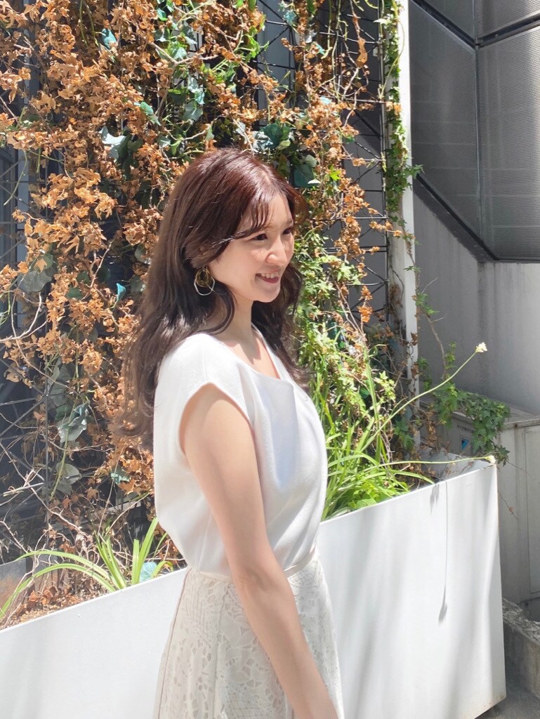 ホワイト系のスカート、ブラック系のサンダル、ホワイト系のニット/セーターを着用したレディースの春コーディネートの2枚目の写真