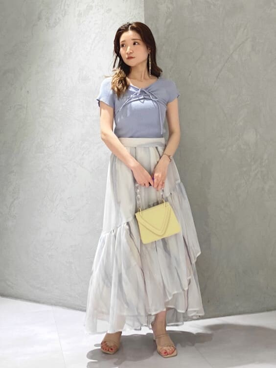 ピンク系のスカート、ブルー系のニット/セーター、ベージュ系のサンダルを着用したレディースの春コーディネートの2枚目の写真