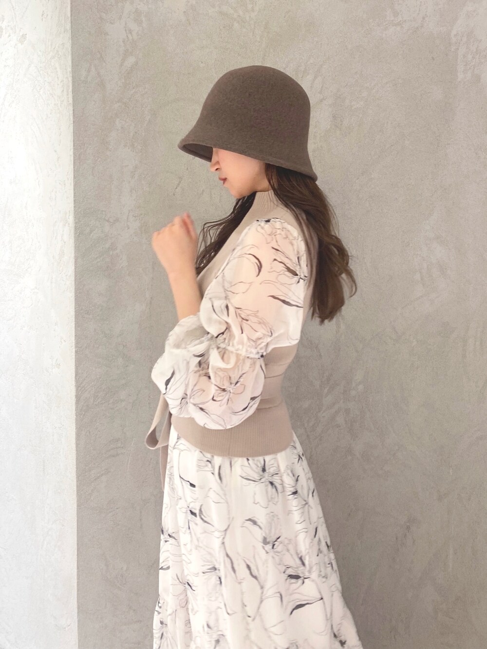 ホワイト系のワンピース、ベージュ系のハンドバッグ、ホワイト系のブーツを着用したレディースの冬コーディネートの5枚目の写真