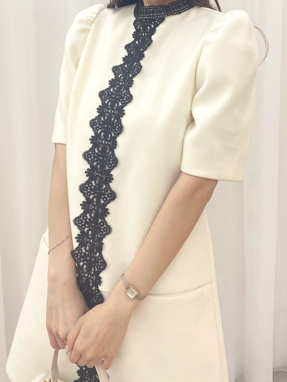 ホワイト系のハンドバッグ、ホワイト系のワンピース、ブラック系のブーツを着用したレディースの夏コーディネートの5枚目の写真