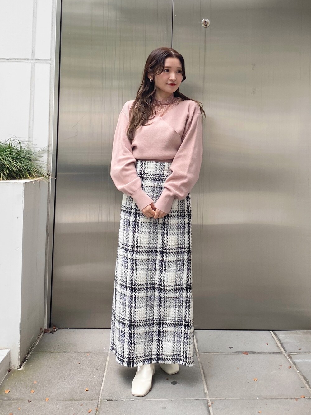 ホワイト系のスカート、ピンク系のニット/セーター、ホワイト系のブーツを着用したレディースの秋コーディネートの3枚目の写真