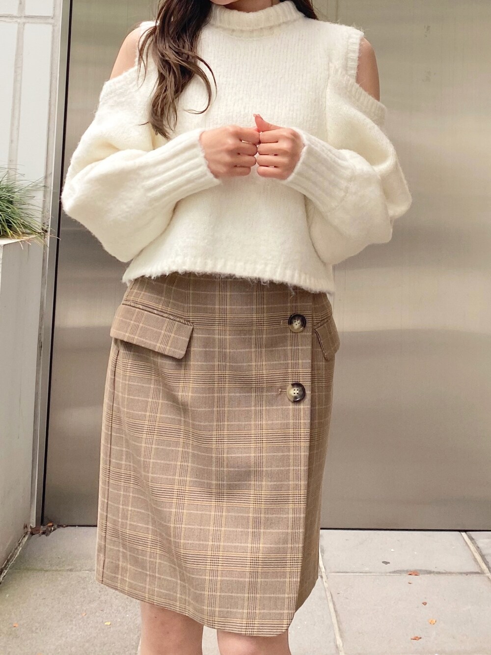 ホワイト系のニット/セーター、ベージュ系のスカート、ホワイト系のブーツを着用したレディースの秋コーディネートの4枚目の写真