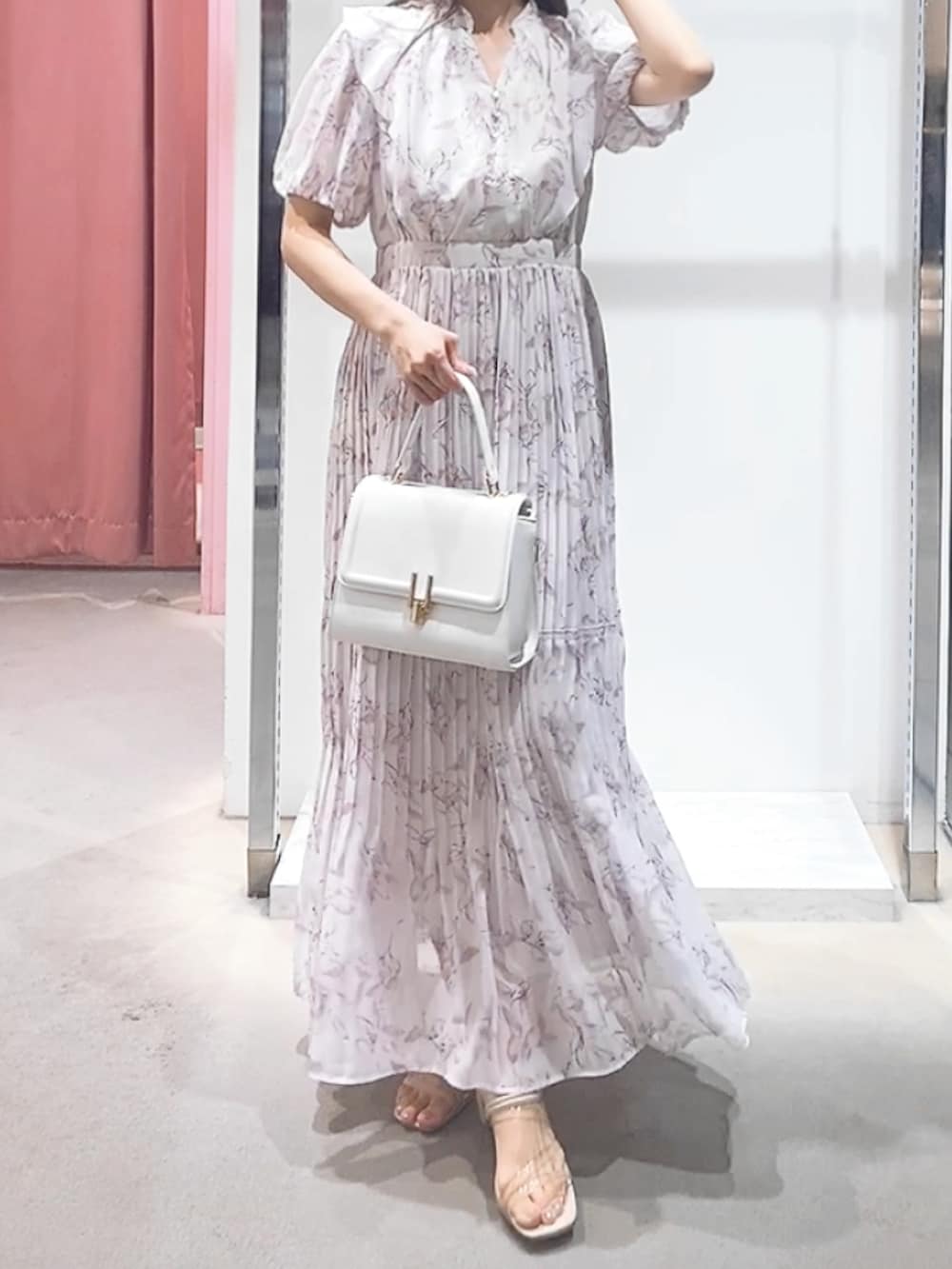 ピンク系のワンピース、ホワイト系のハンドバッグを着用したレディースの夏コーディネートの2枚目の写真