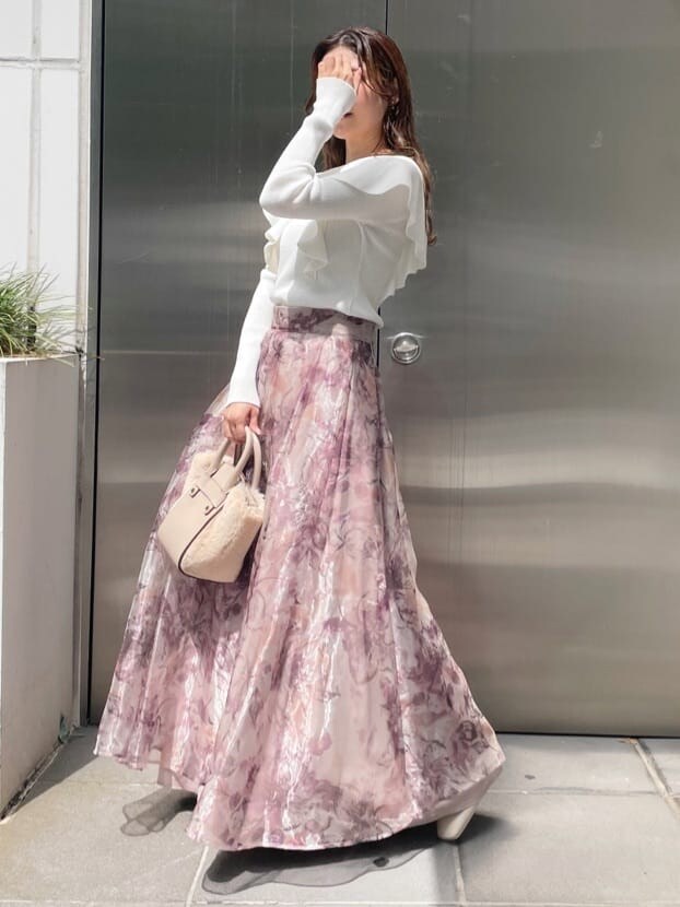 ホワイト系のハンドバッグ、ピンク系のスカート、ホワイト系のニット/セーターを着用したレディースの秋コーディネートの6枚目の写真