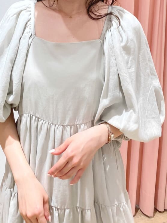 グリーン系のワンピース、ベージュ系のブーツ、ベージュ系のキャスケットを着用したレディースの秋コーディネートの3枚目の写真