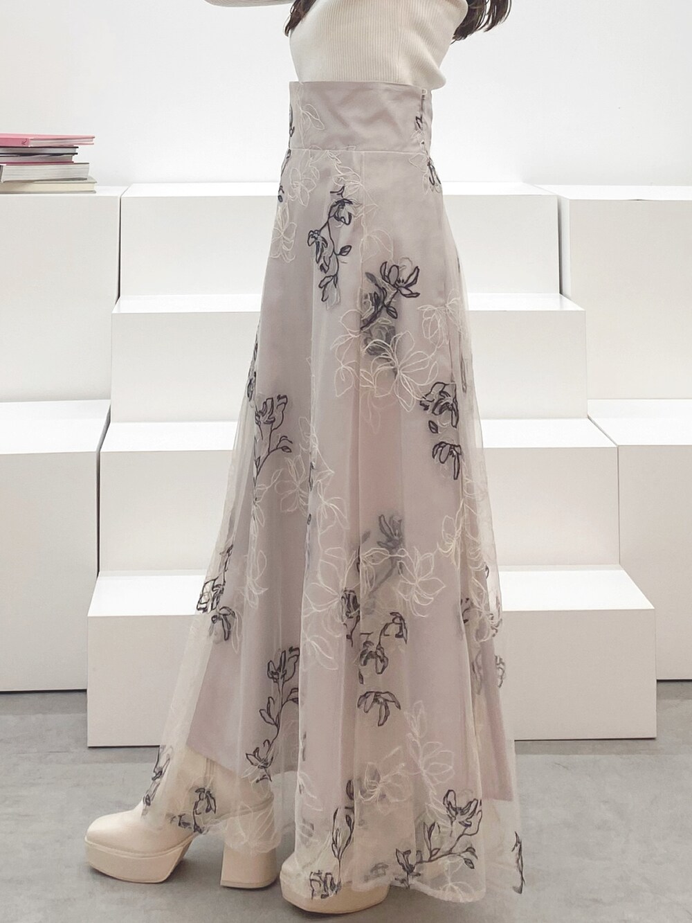 ホワイト系のブーツ、ホワイト系のニット/セーター、ベージュ系のスカートを着用したレディースの秋コーディネートの4枚目の写真