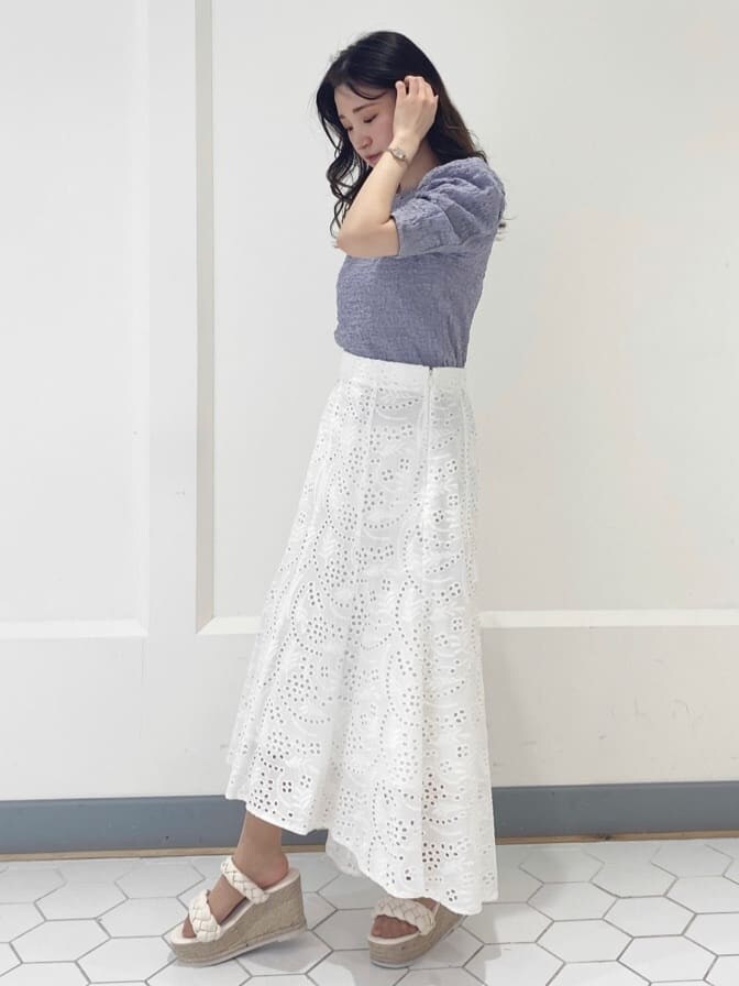 ホワイト系のスカート、パープル系のTシャツ/カットソー、ホワイト系のサンダルを着用したレディースの春コーディネートの3枚目の写真