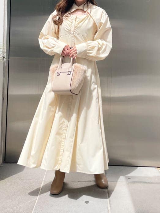 ベージュ系のブーツ、ホワイト系のハンドバッグ、ホワイト系のワンピースを着用したレディースの秋コーディネートの6枚目の写真