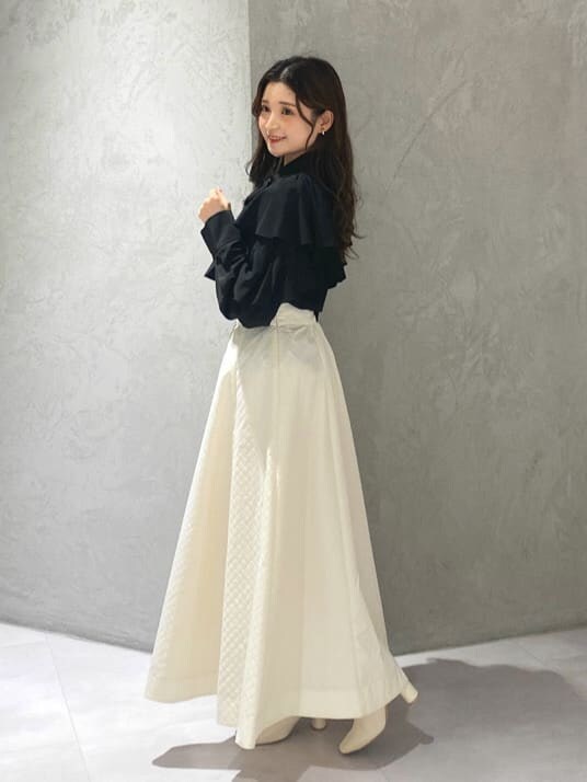 ホワイト系のブーツ、ブラック系のシャツ/ブラウス、ホワイト系のスカートを着用したレディースの夏コーディネートの3枚目の写真