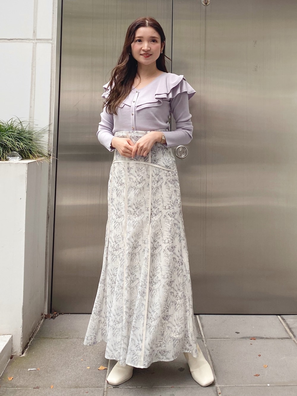 ホワイト系のブーツ、パープル系のニット/セーター、ホワイト系のスカートを着用したレディースの秋コーディネートの2枚目の写真