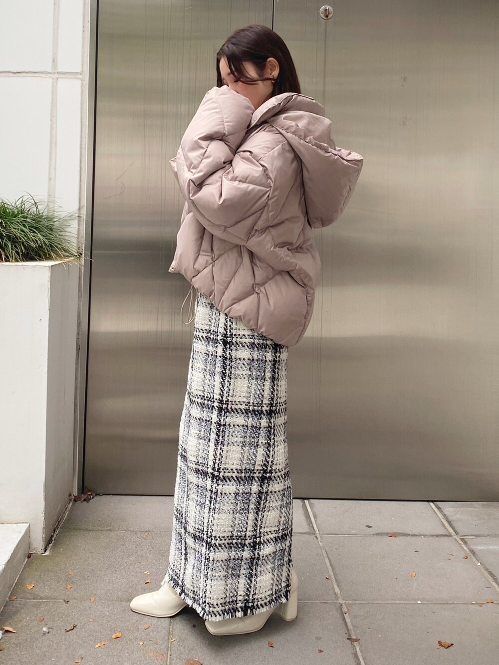 ホワイト系のブーツ、ホワイト系のスカート、ベージュ系のダウンジャケット/コートを着用したレディースの秋コーディネートの4枚目の写真