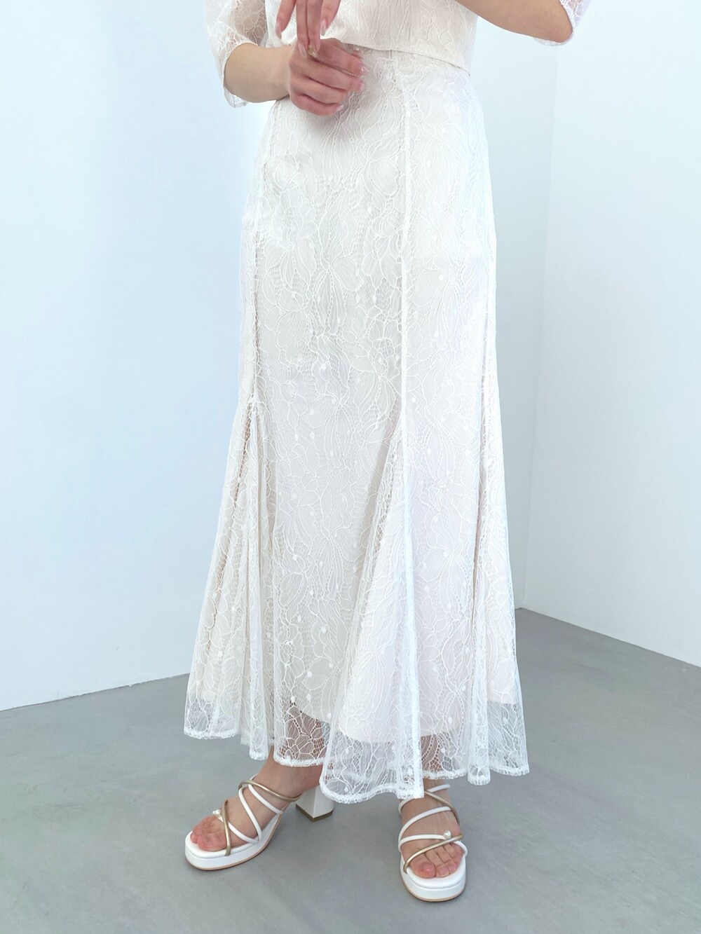 ホワイト系のスカート、パープル系のシャツ/ブラウス、ホワイト系のサンダルを着用したレディースの冬コーディネートの7枚目の写真