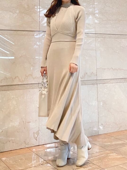 ベージュ系のワンピース、ホワイト系のハンドバッグを着用したレディースの冬コーディネートの5枚目の写真