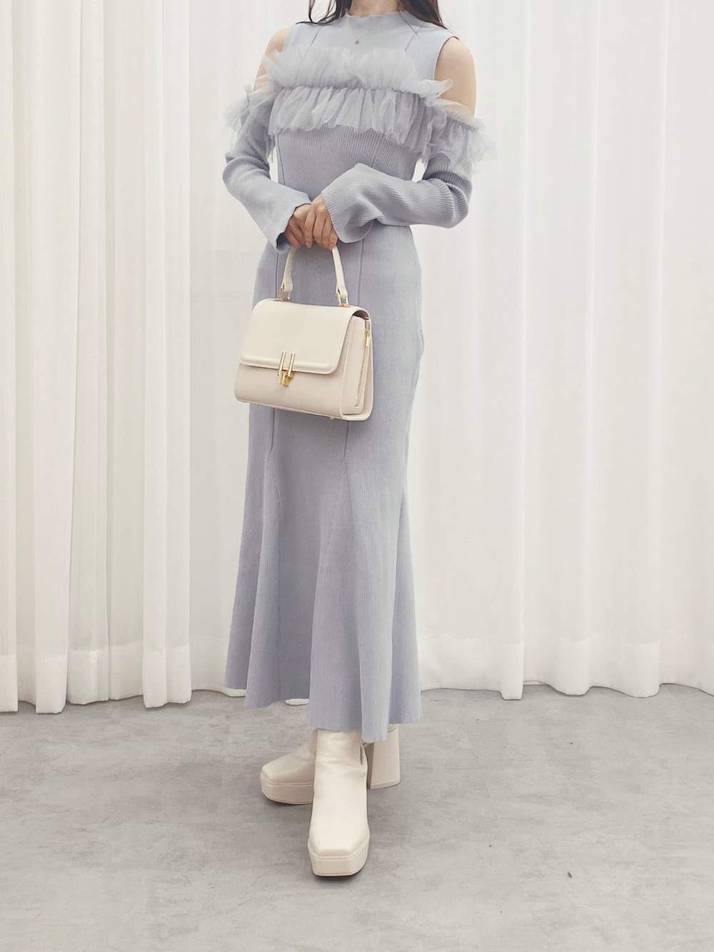 ブルー系のワンピース、ホワイト系のブーツ、グレー系のムートンコートを着用したレディースの秋コーディネートの5枚目の写真