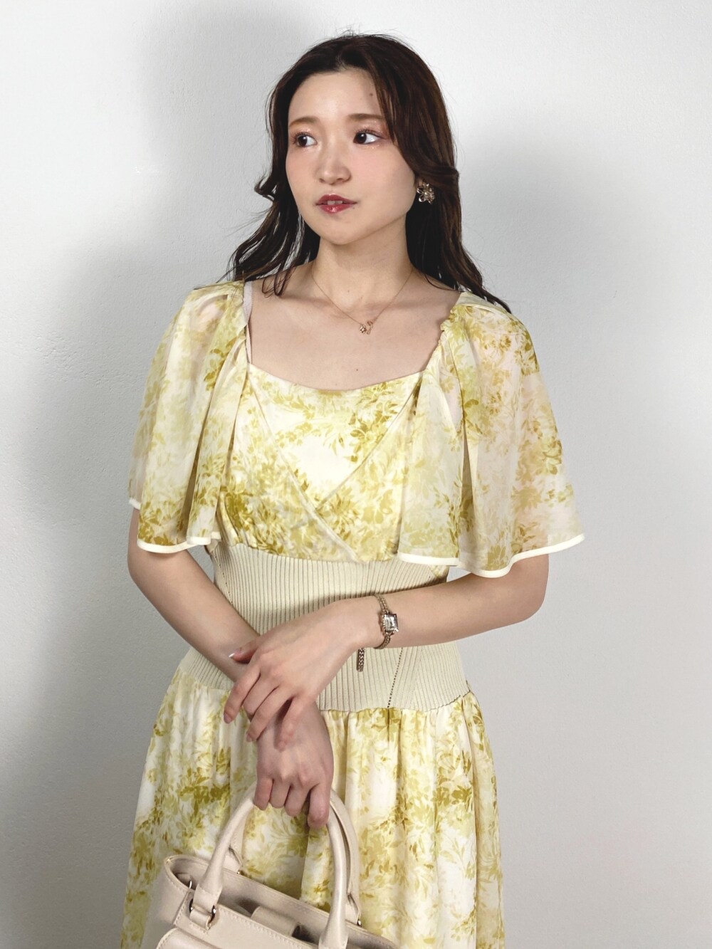 ホワイト系のハンドバッグ、その他のサンダル、イエロー系のワンピースを着用したレディースの夏コーディネートの4枚目の写真