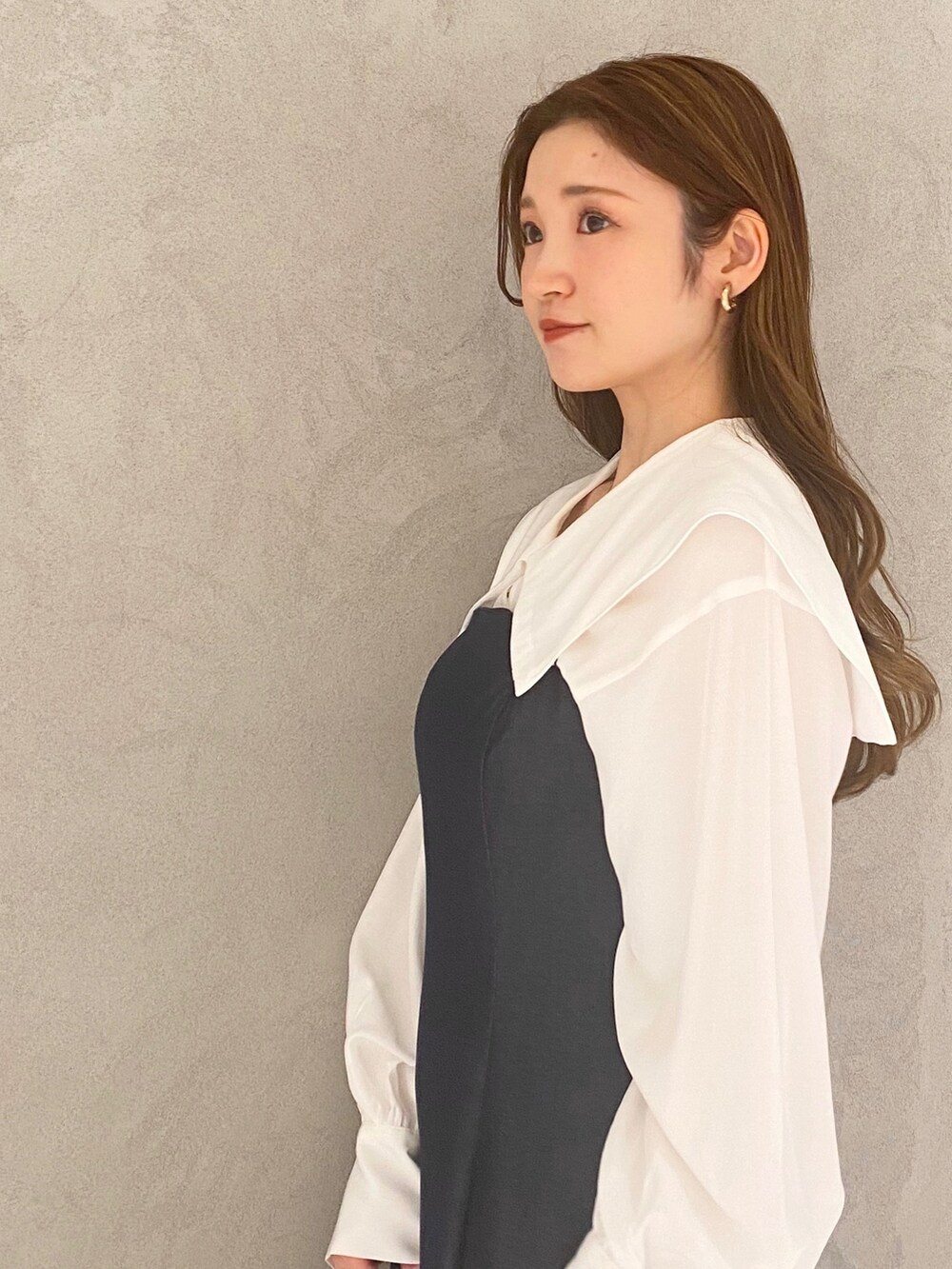 ホワイト系のブーツ、ブルー系のワンピース、ホワイト系のハンドバッグを着用したレディースの冬コーディネートの5枚目の写真