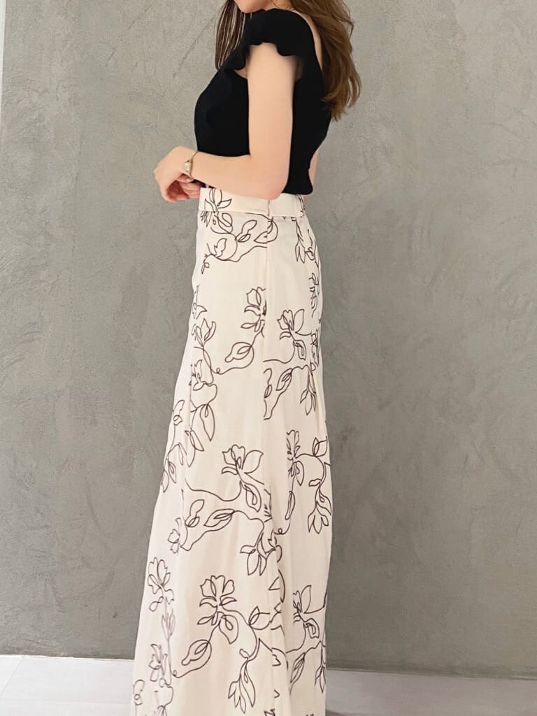 ブラック系のショルダーバッグ、ブラック系のニット/セーター、ホワイト系のスカートを着用したレディースの夏コーディネートの5枚目の写真